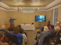 a man giving a presentation to a group of people in a room